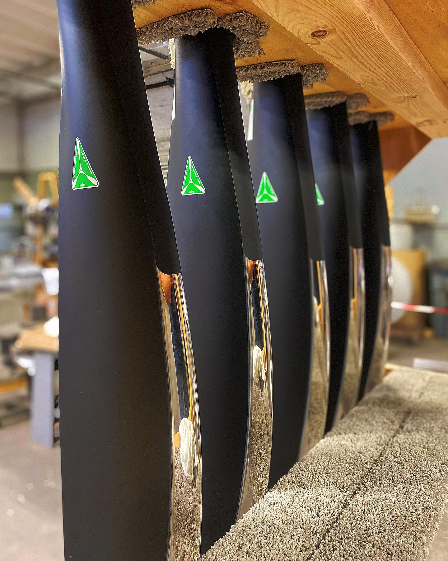 A collection of black and green knives neatly arranged on a shelf, highlighting their modern aesthetic.
