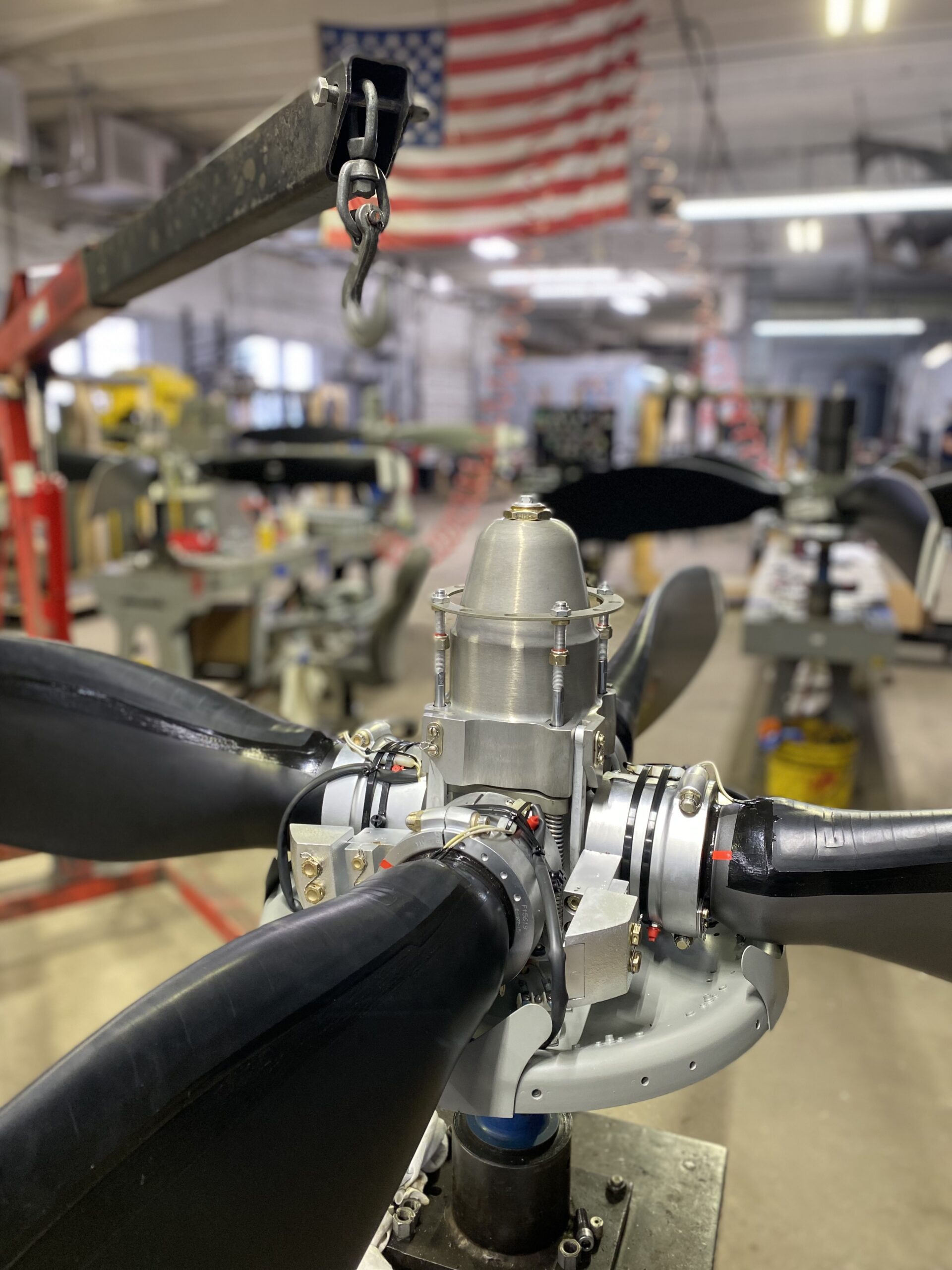 An industrial scene featuring a plane's propeller in a factory, highlighting the craftsmanship and engineering involved in its production.