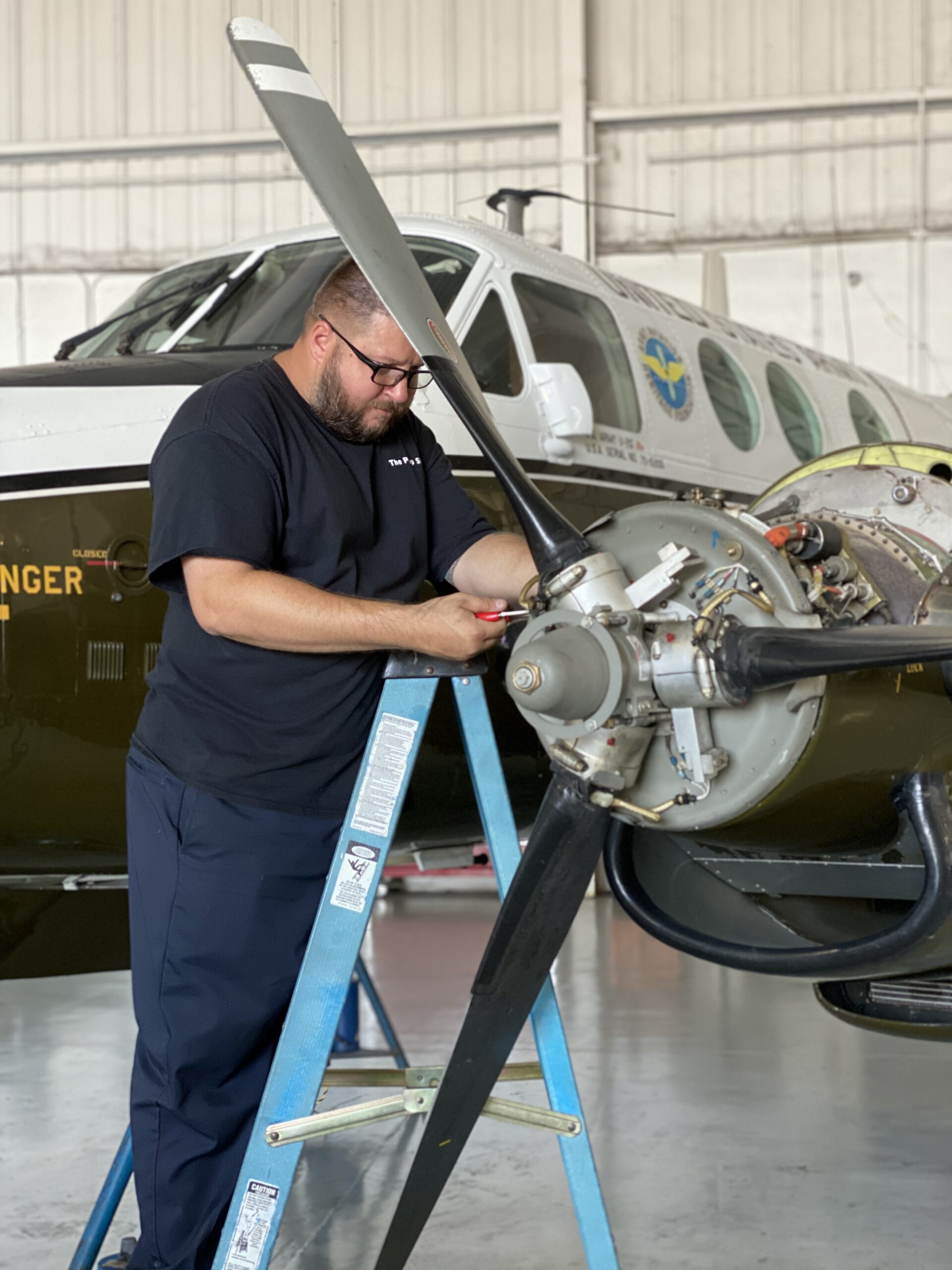 An individual engaged in aircraft maintenance, demonstrating expertise and attention to detail in a hangar setting.